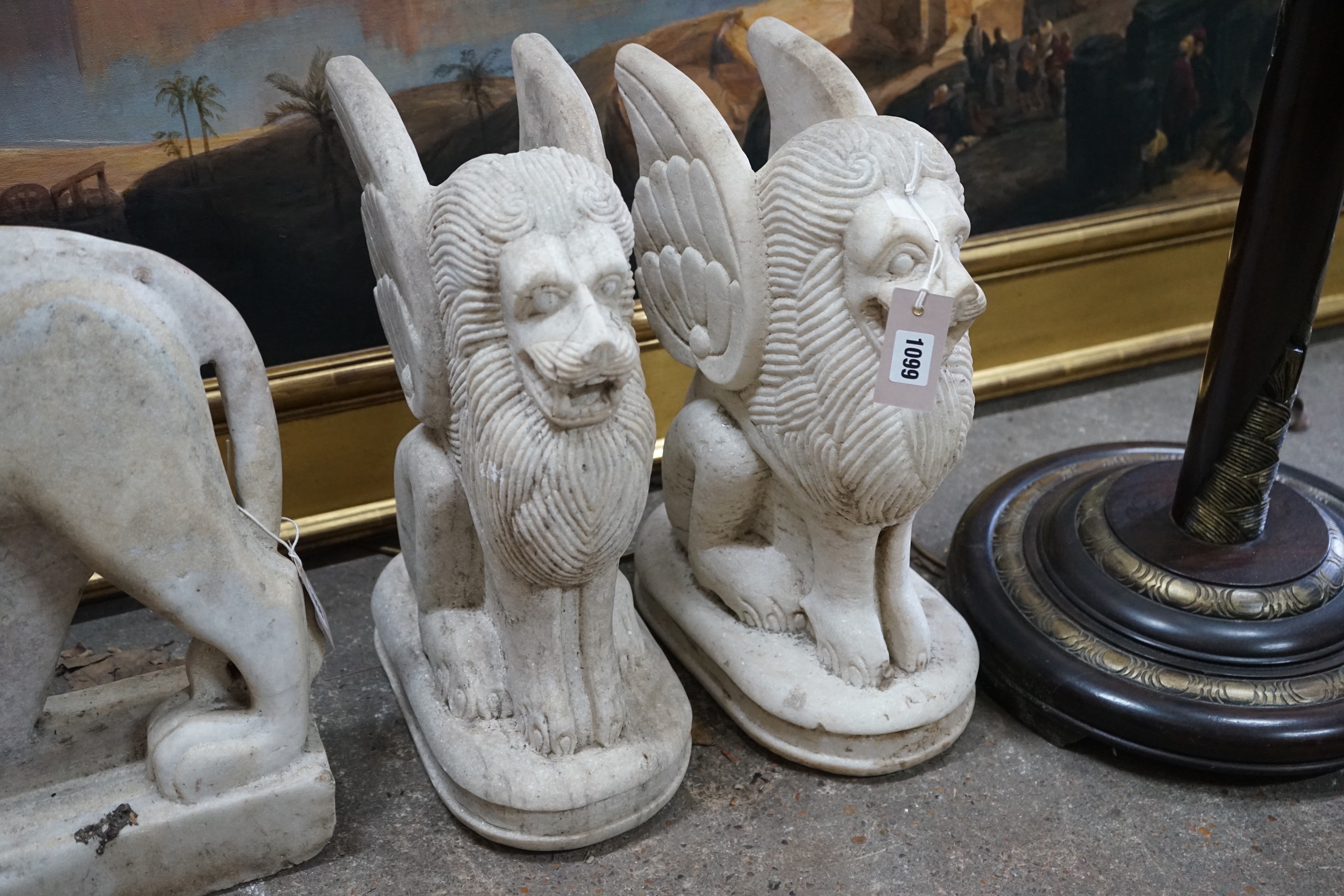 A pair of South East Asian carved stone winged lions, height 40cm